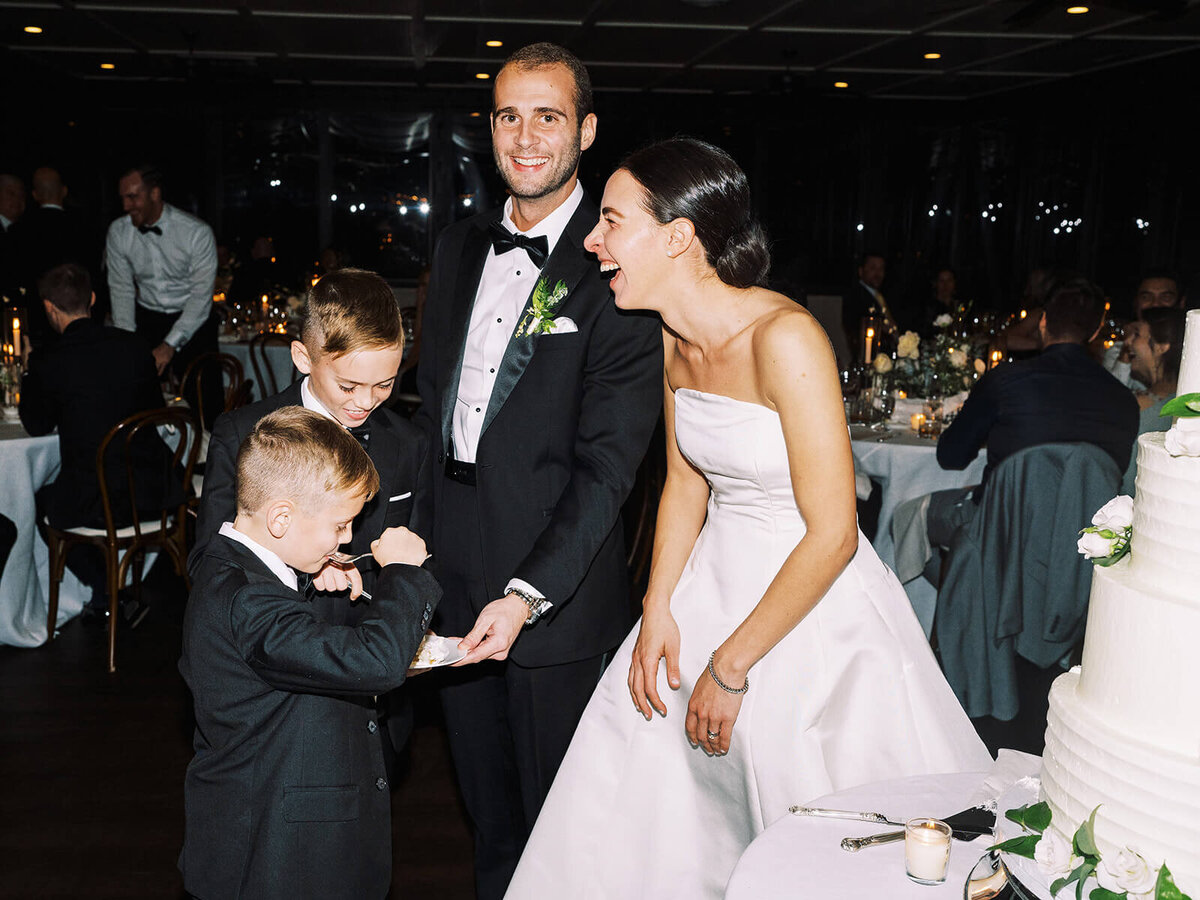 43. groom-bride-laughing-wedding-cake-cutting-reception