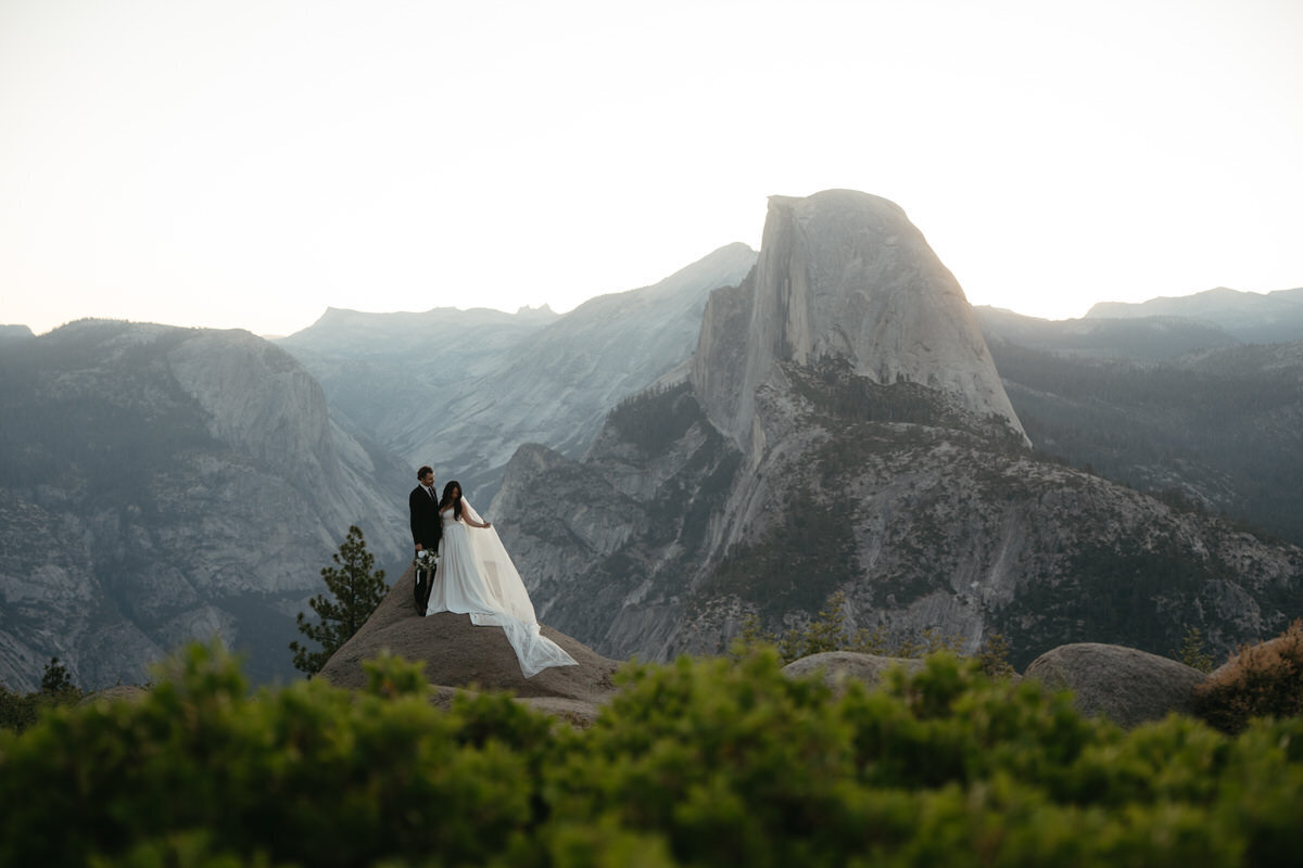 Wedding couple to the left and Half Dome to the right during a Glacier Point Amphitheater Wedding