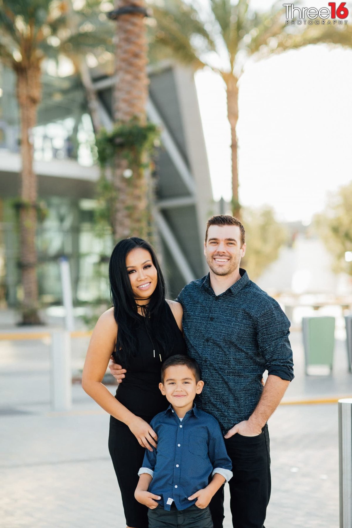 Engaged couple pose with their son for an engagement photo session