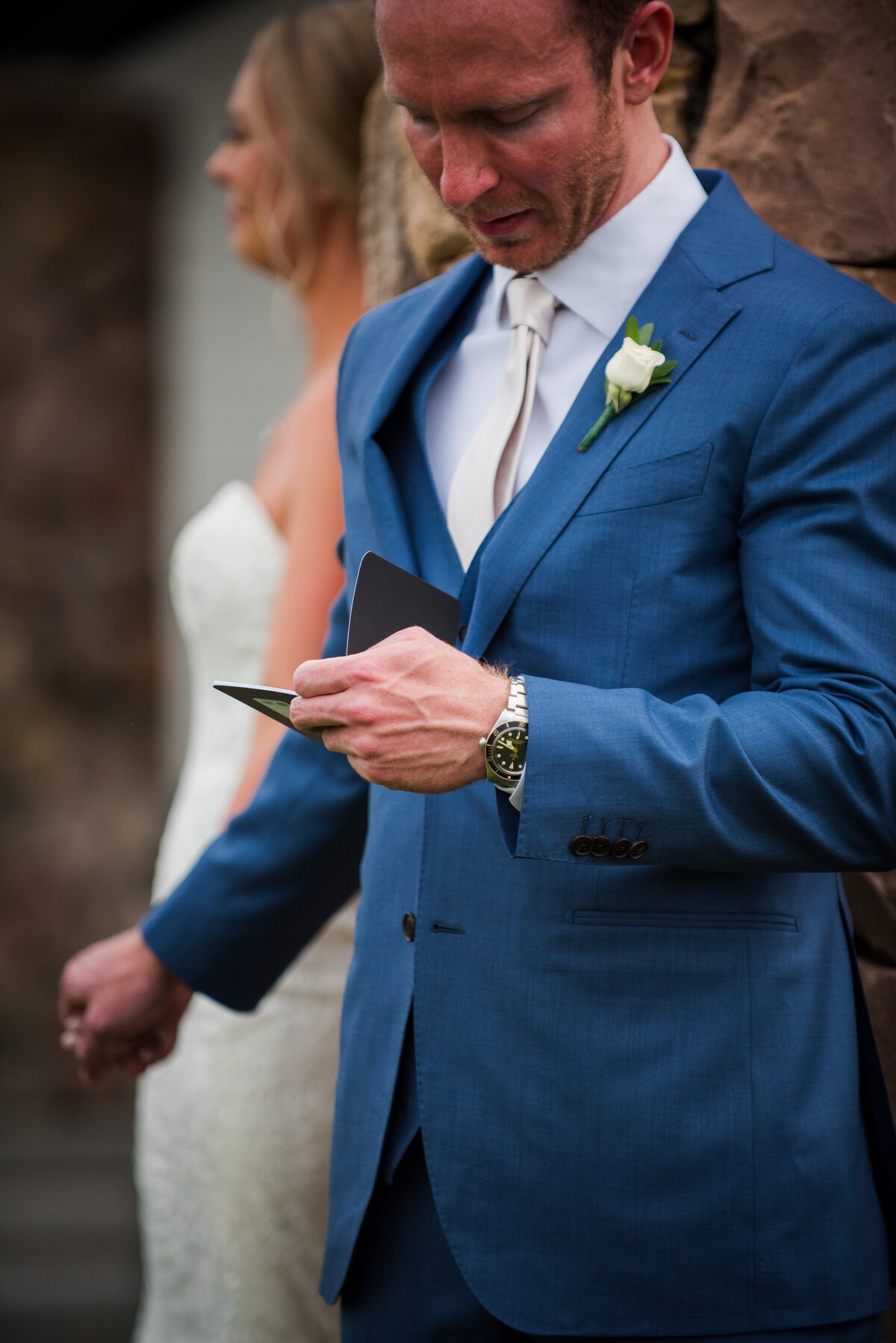 A close up shot of a groom reading his vows to his bride during his first touch with his bride.