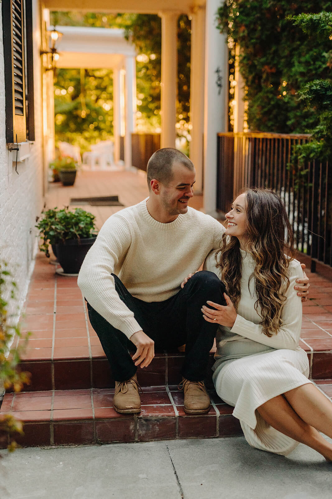 Couple sat on steps of a home at Finger Lakes engagement session