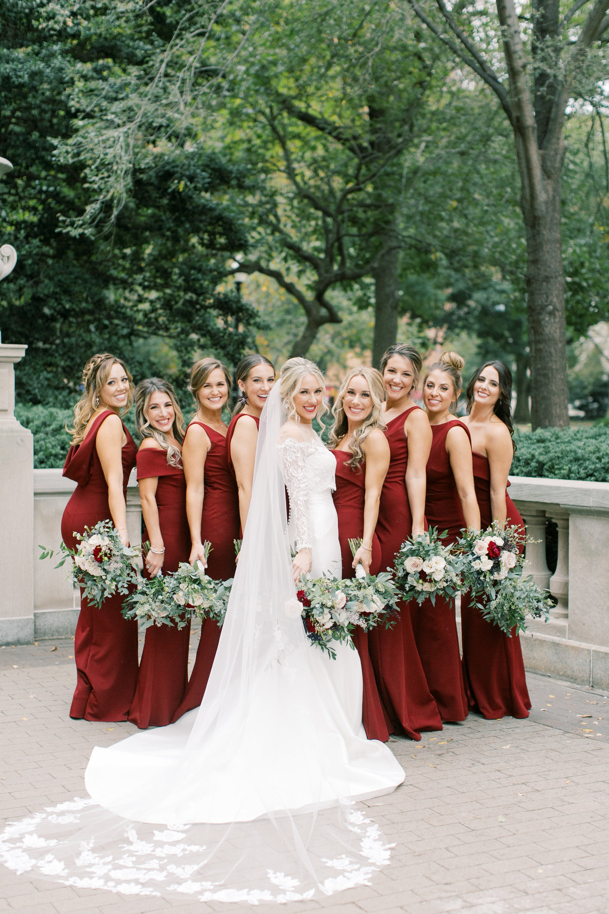 bride standing with all her bridesmaids holding bouquets