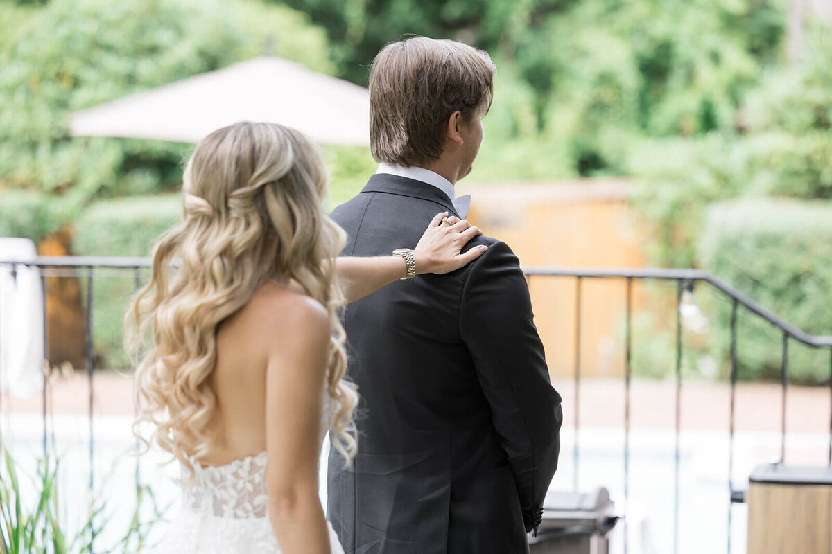 Bride tapping groom on the shoulder for first look at Long Island wedding