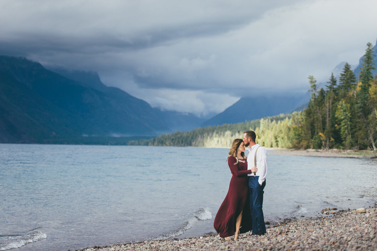 couple holding each other by lake