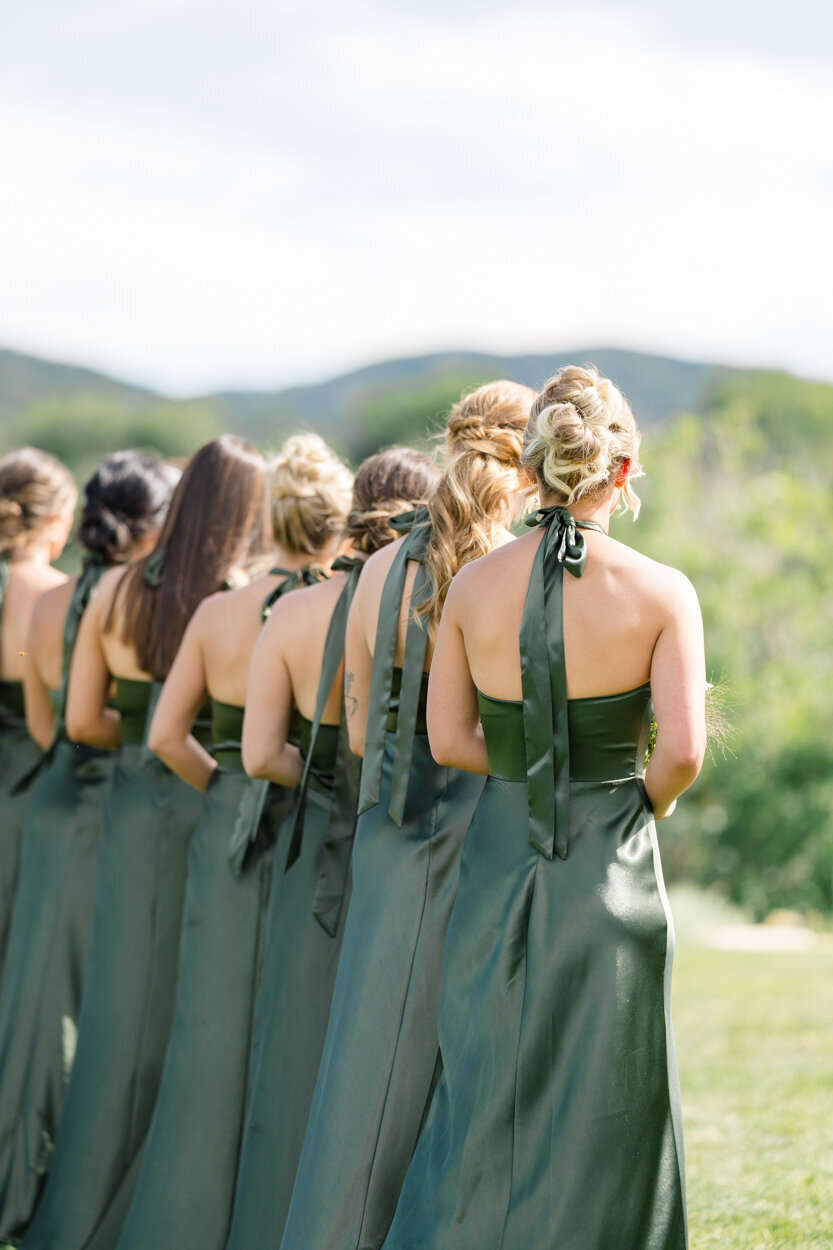 bridesmaids in green standing during the ceremony
