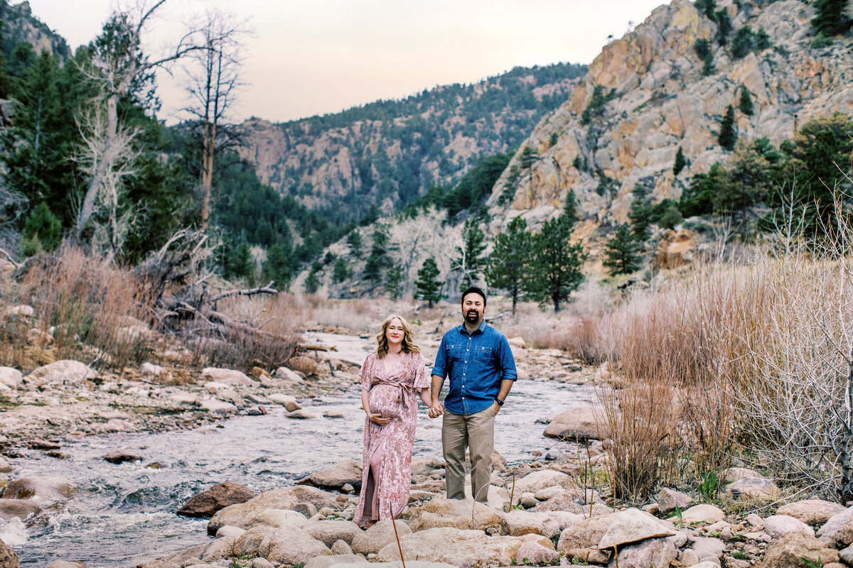 pregnant couple stand along colorado river