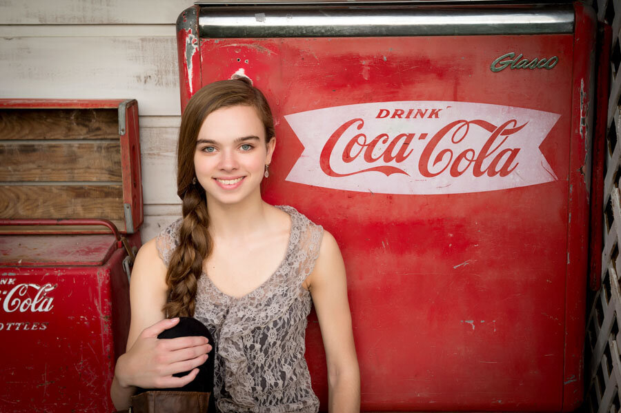 high school senior with vintage coke machine