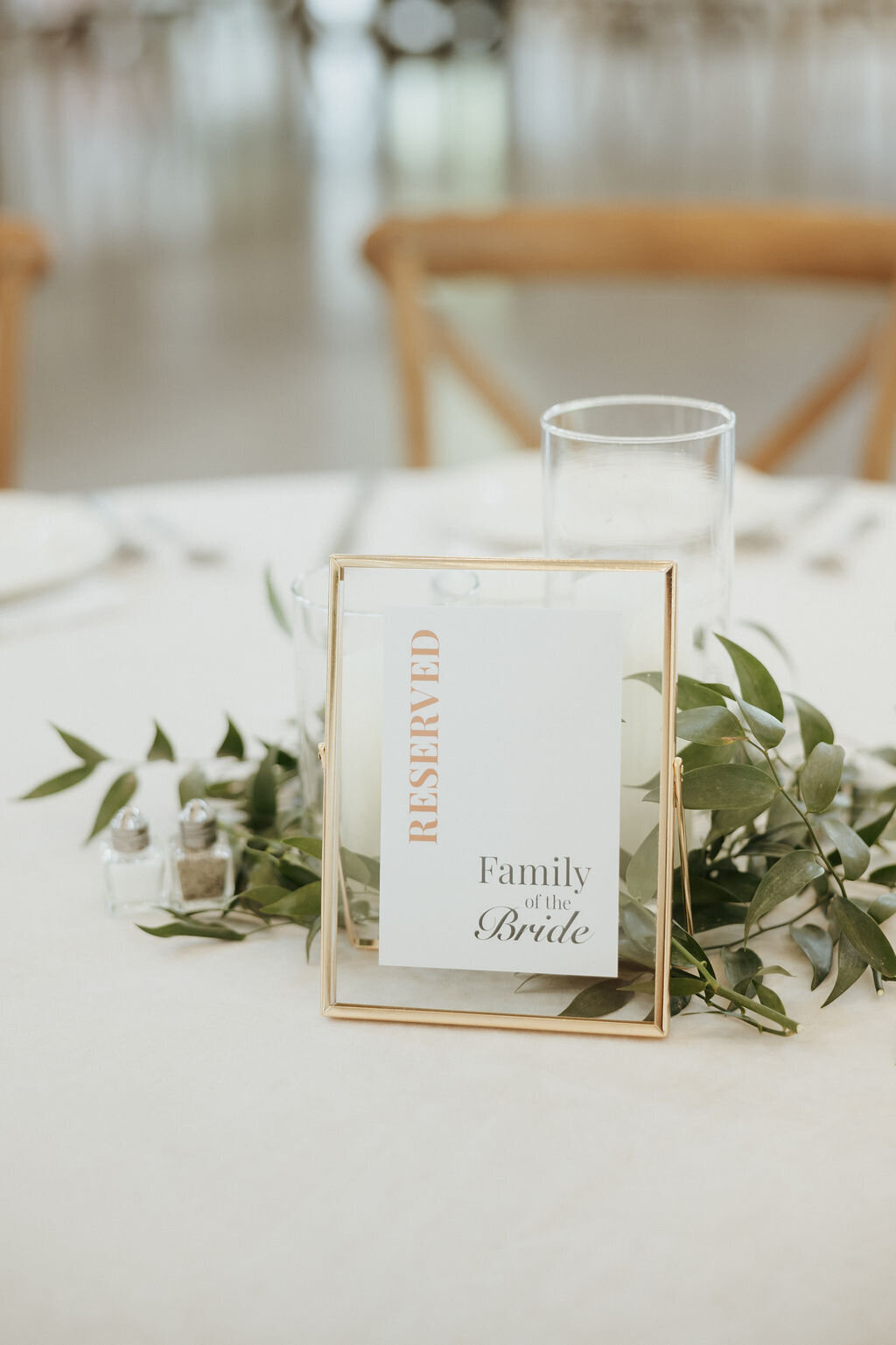 custom wedding signage for reserved table in gold floating frame with greenery details