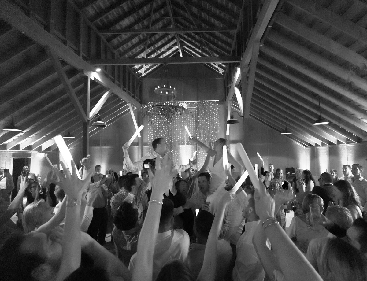 black and white image of wedding dancing inside barn