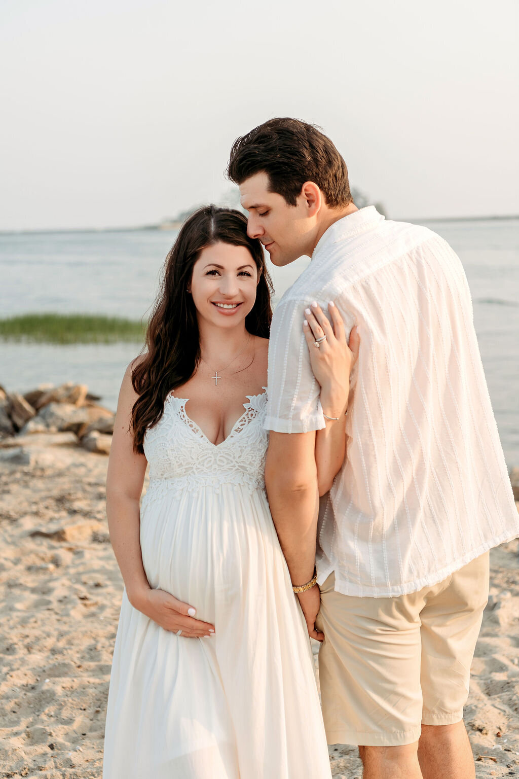 Connecticut maternity photographer photographs intimate couples beach portrait in white attire