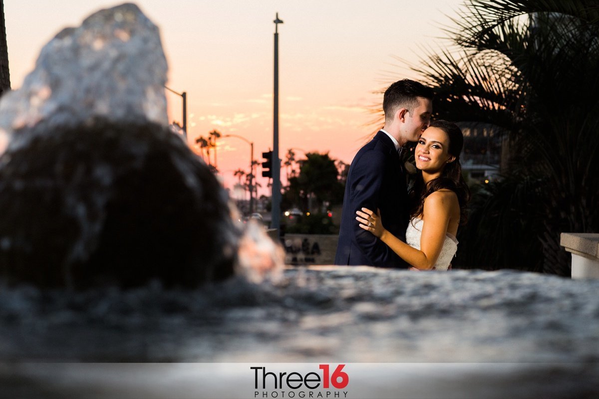 Sweet moment for Bride and Groom near a water fountain