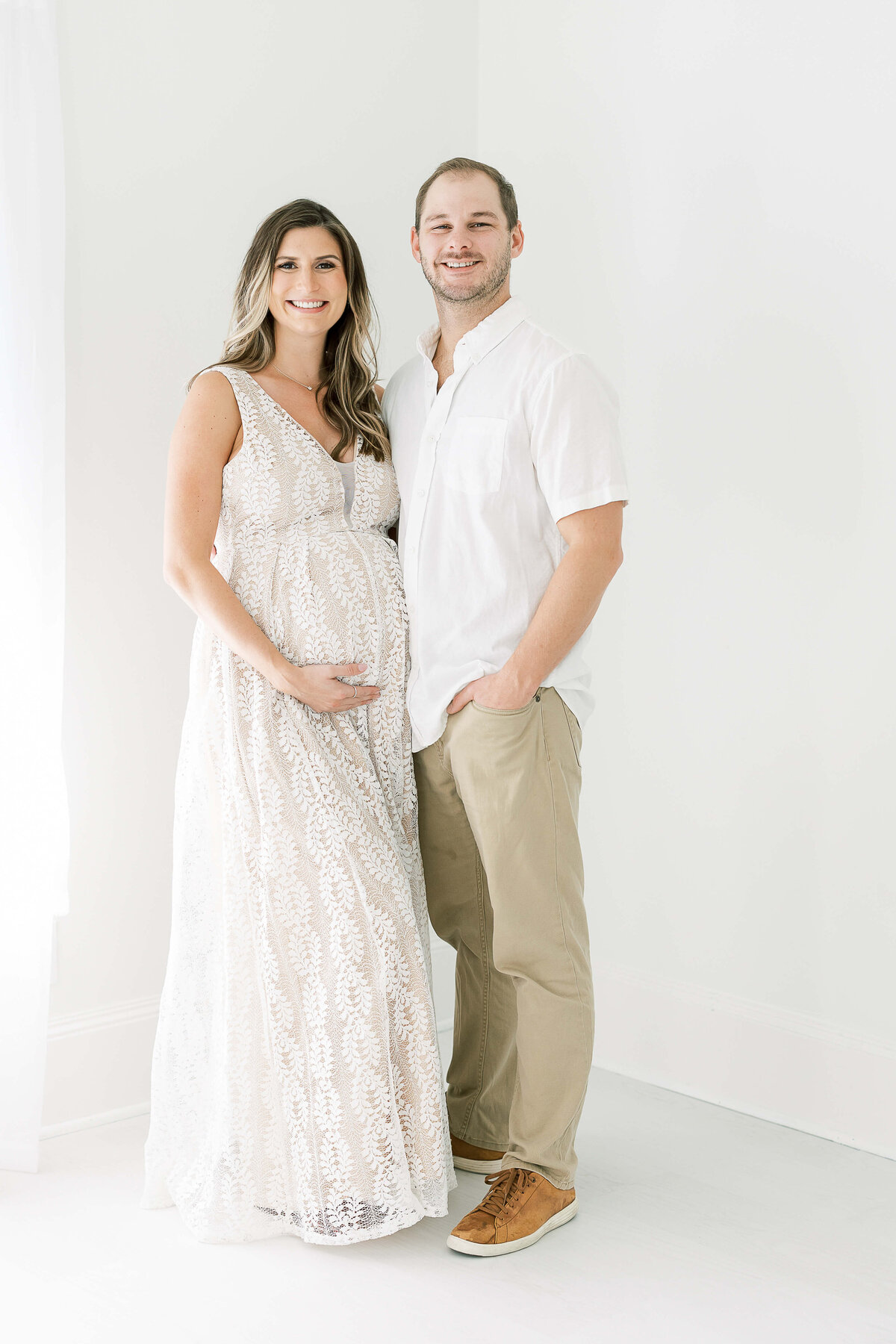 a portrait of an expecting couple wearing neutral colors
