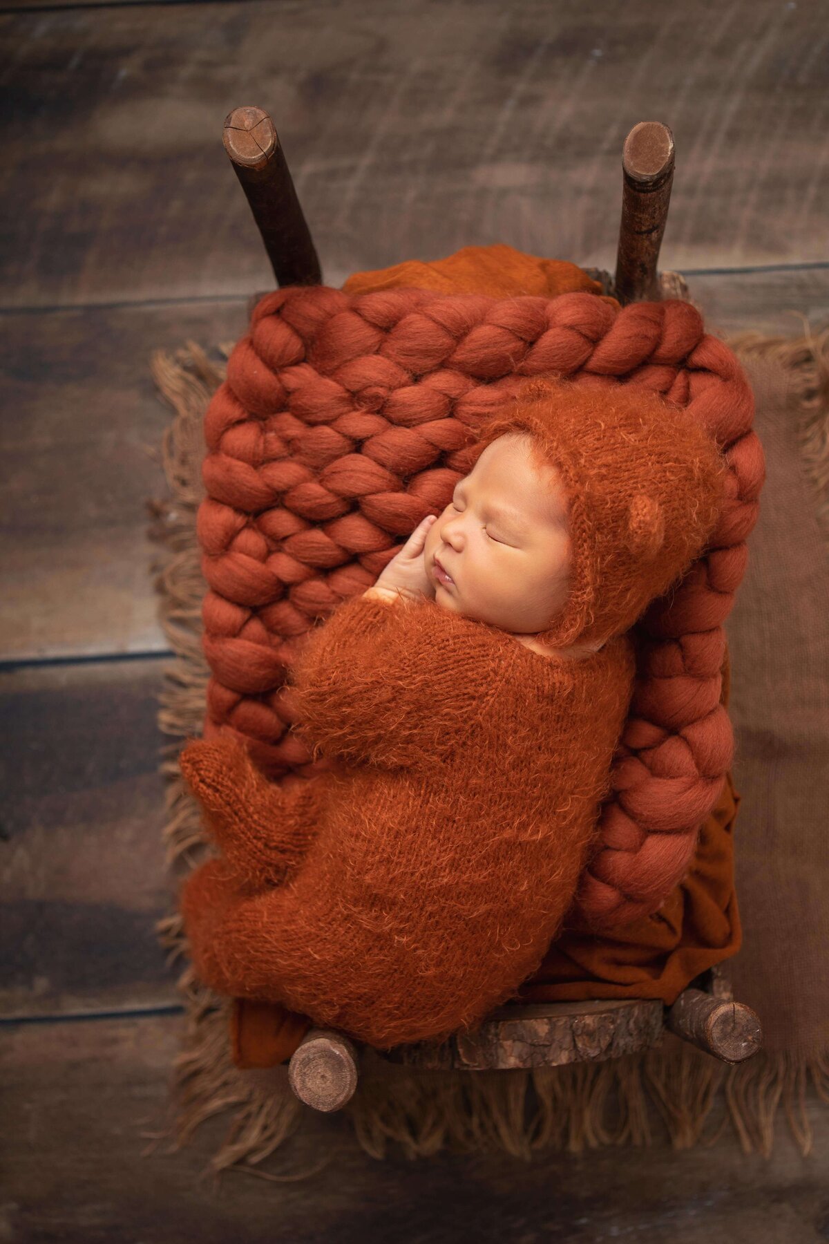 baby on a tiny wooden bed in photoshoot