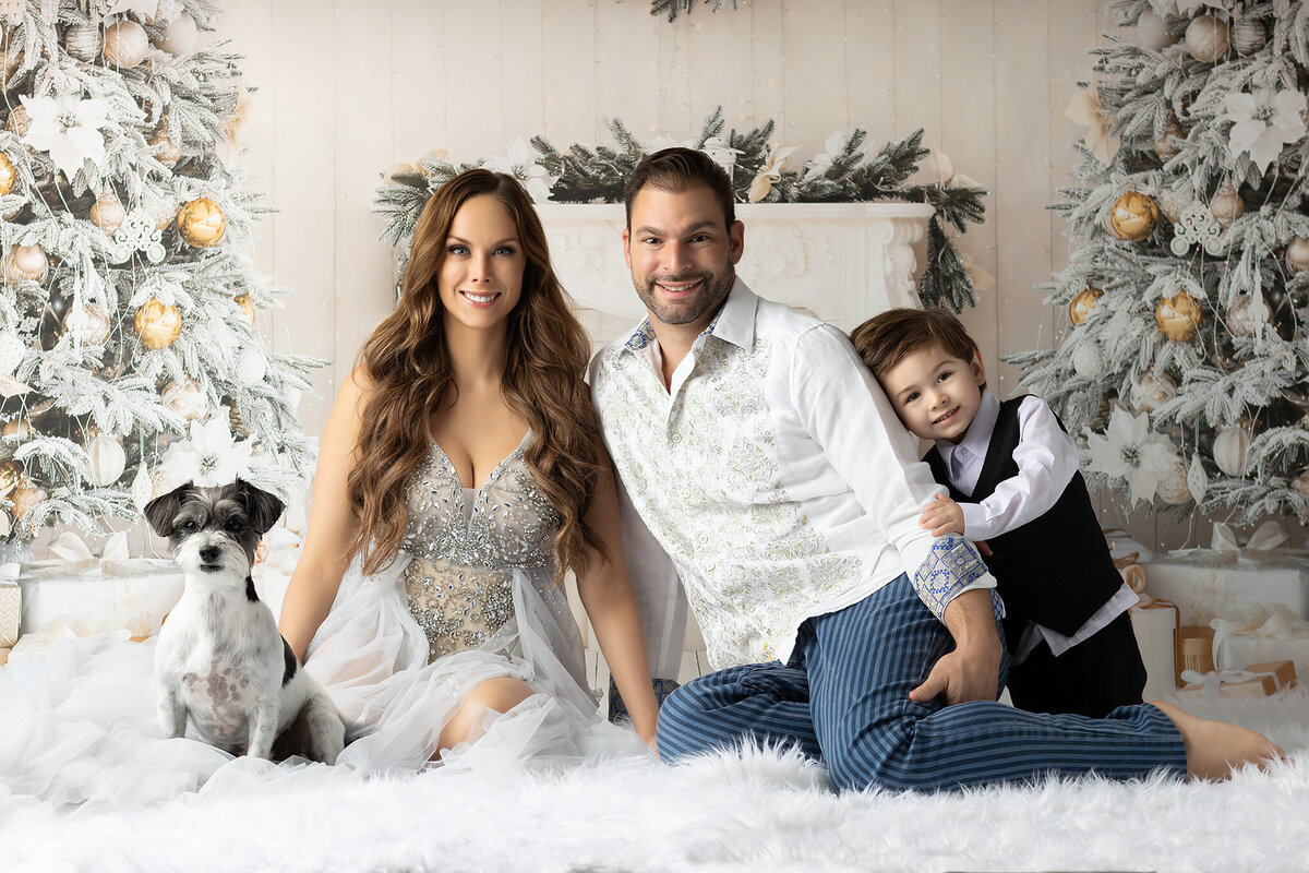 A family portrait in Dallas by a Dallas family photographer, featuring festive holiday cheer with their dog.
