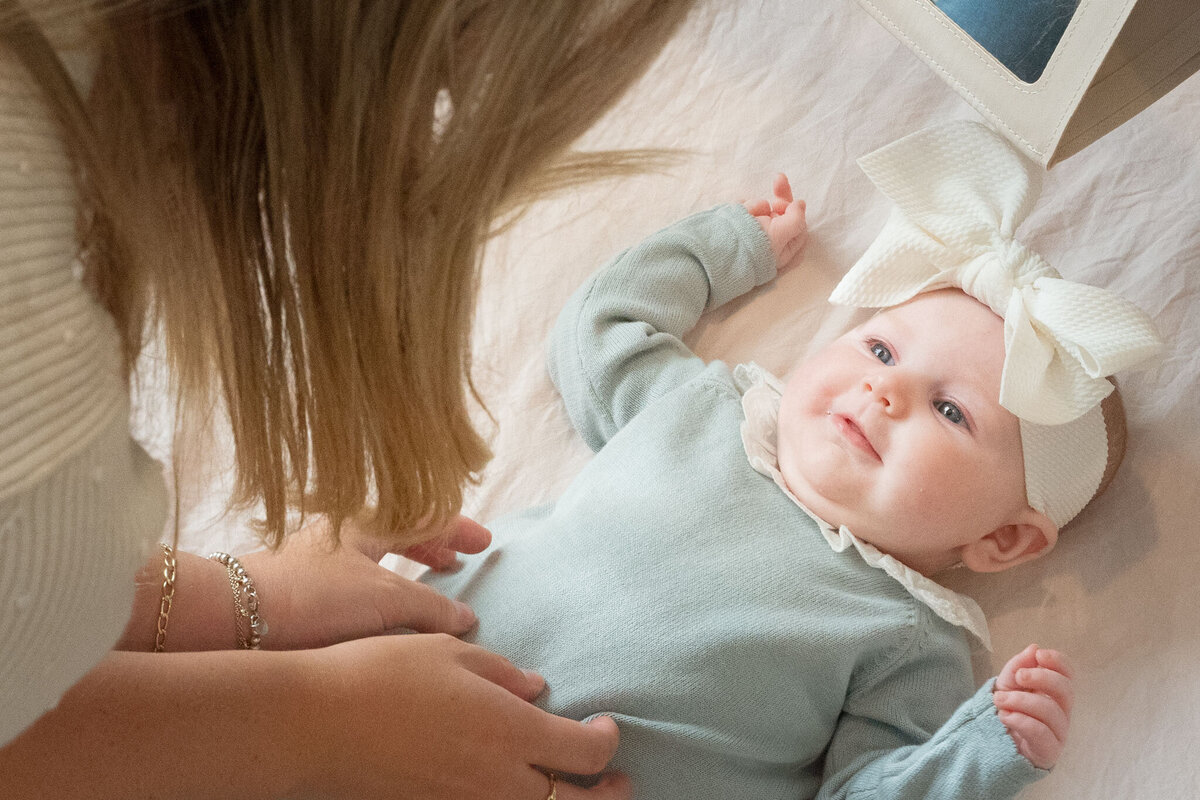 sweet mama tickles baby in home newborn session