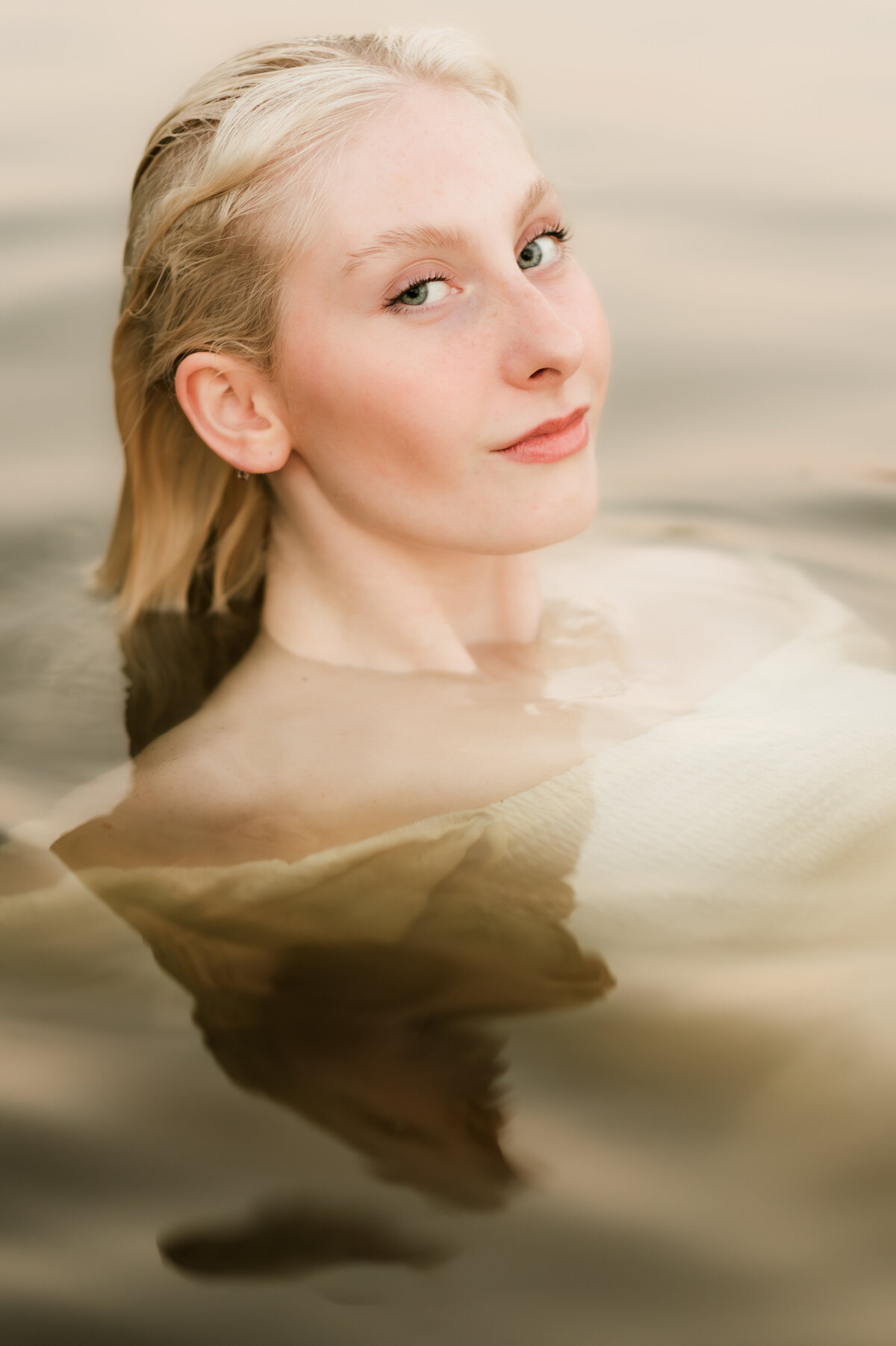 Girl laying down submerged in the water of the St. Croix river