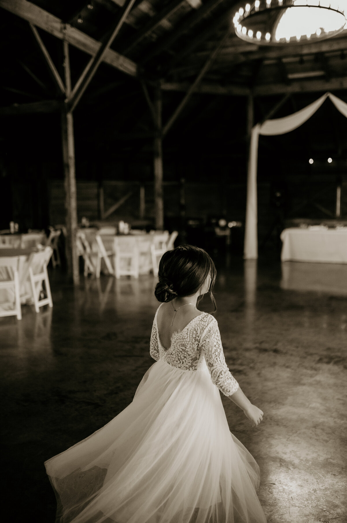 flower girl dancing alone in a bar in a lace and tulle dress