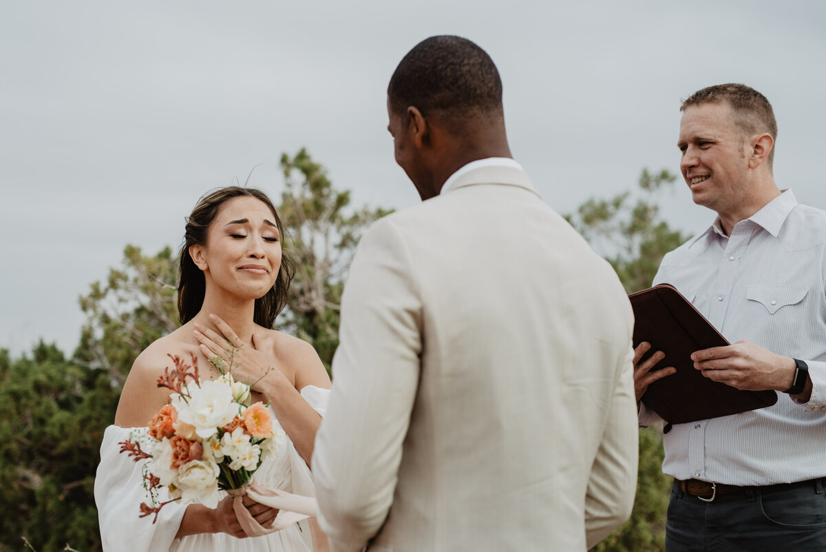 Utah Elopement Photographer captures bride touching chest during ceremony
