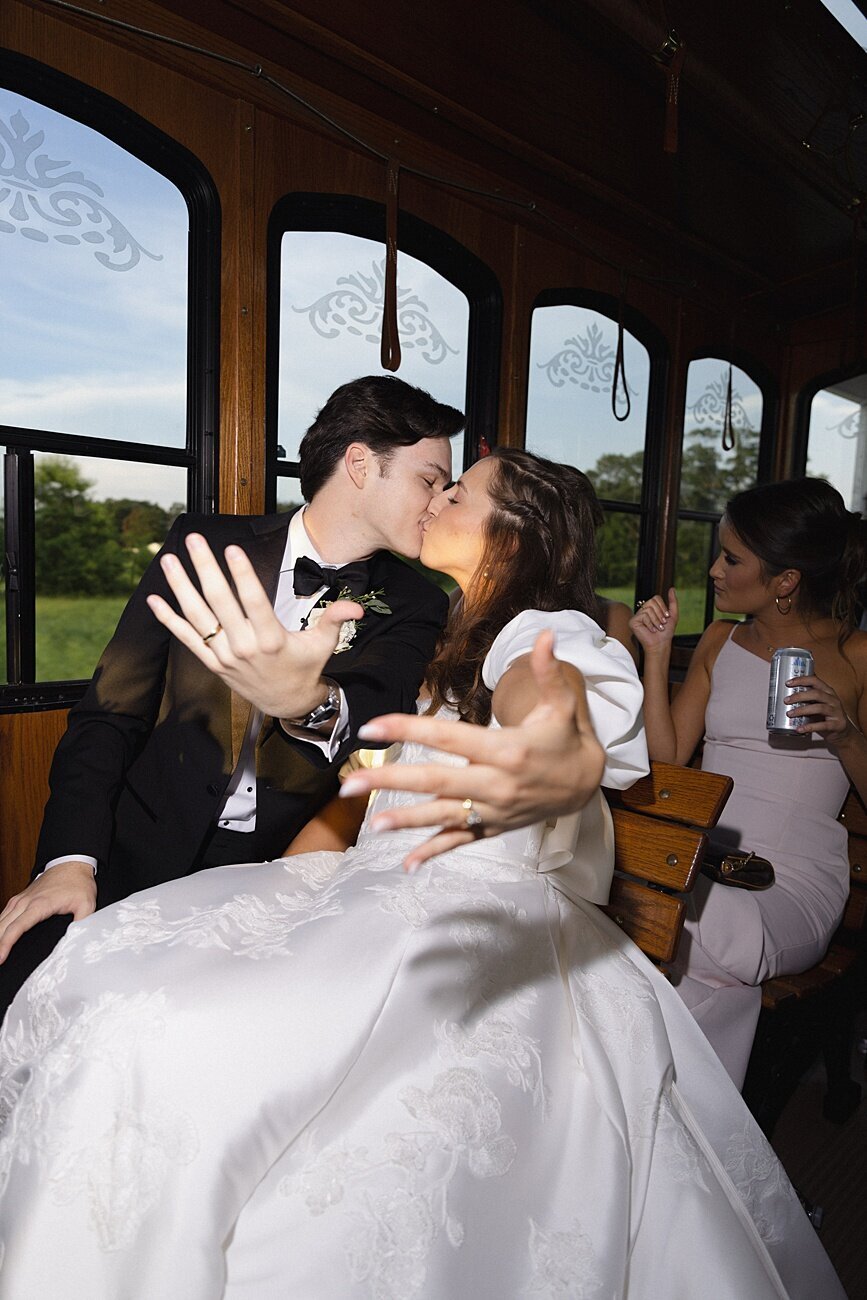 Newyleds kiss while showing off wedding rings on party bus
