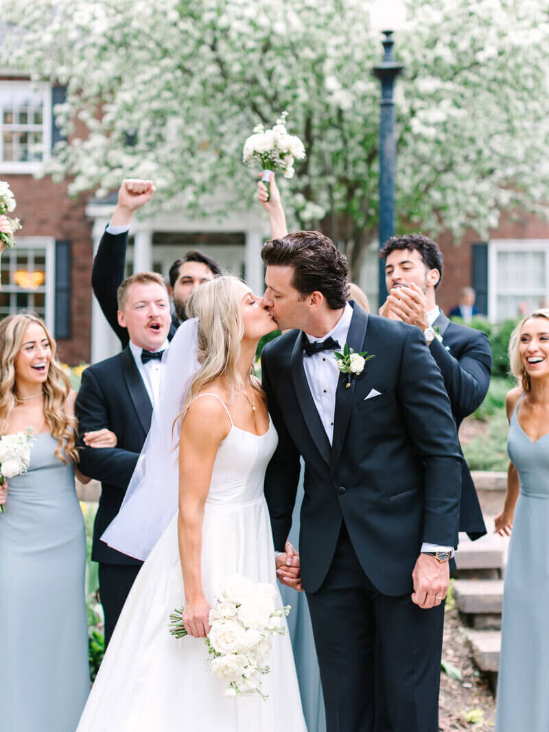 Bride and groom kissing in front of bridal party designed by wedding planners chicago