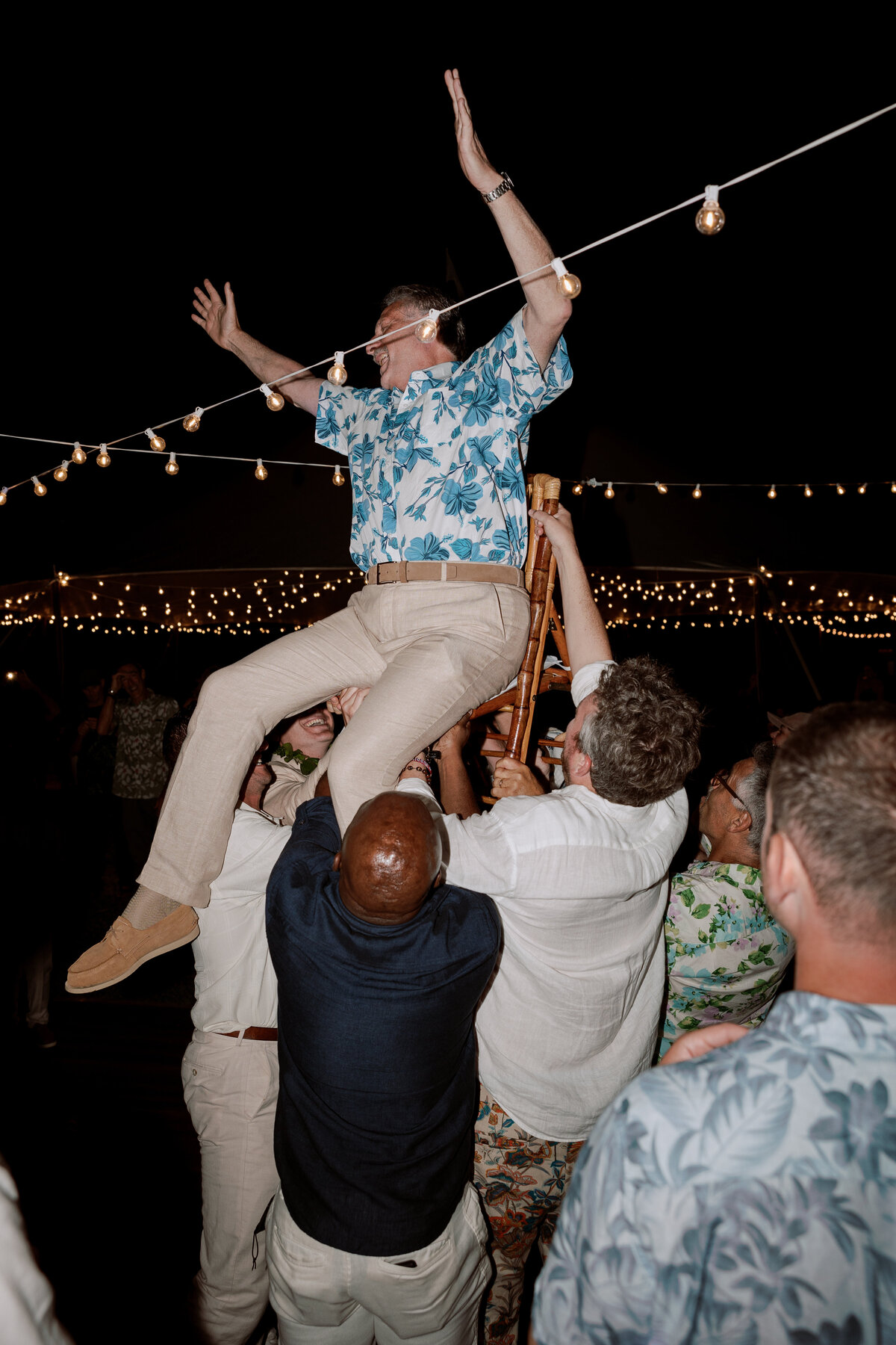 Guest lifted in a chair during a joyful Jewish celebration on the dancefloor, captured on film in a documentary wedding photography style — Carmel wedding photography by Kate Winters Photography.