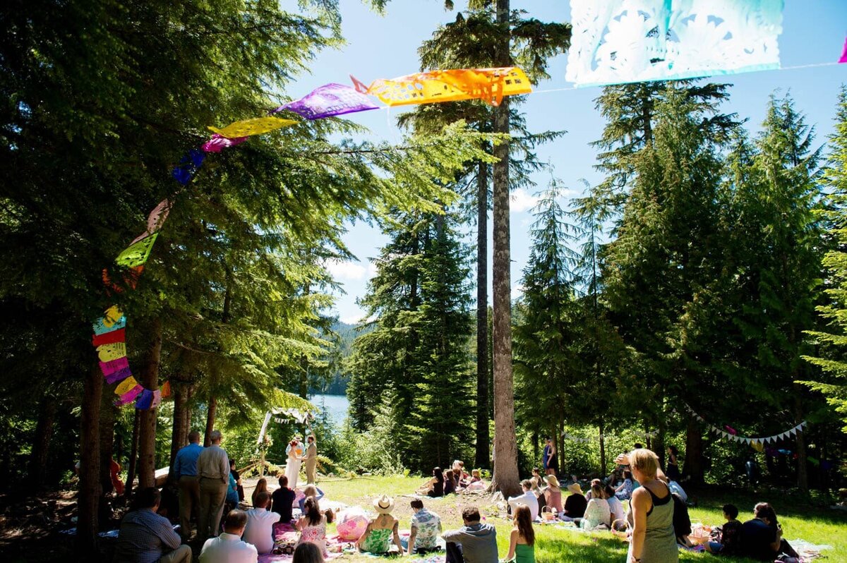 colorful mexican paper flags fly in the air around an outdoor wedding ceremony