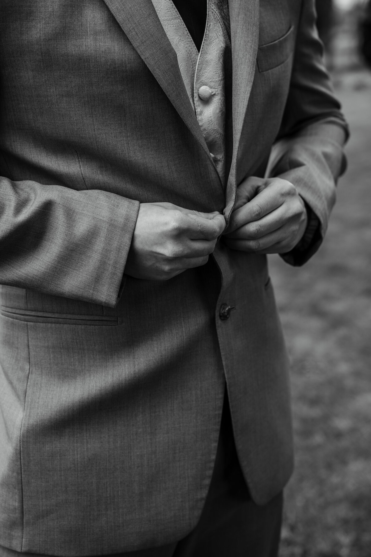 Groom buttoning suit jacket