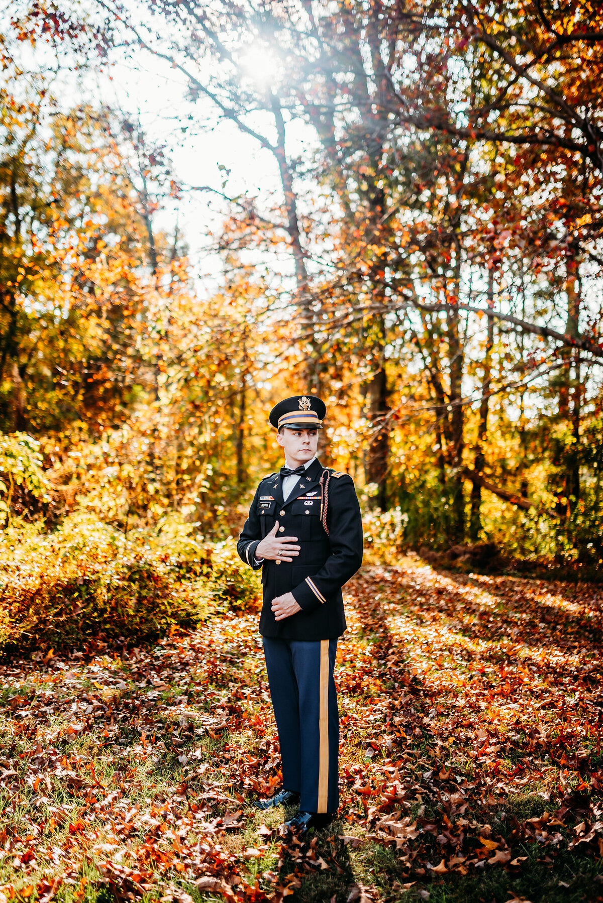 a military groom in his uniform in the woods during golden hour