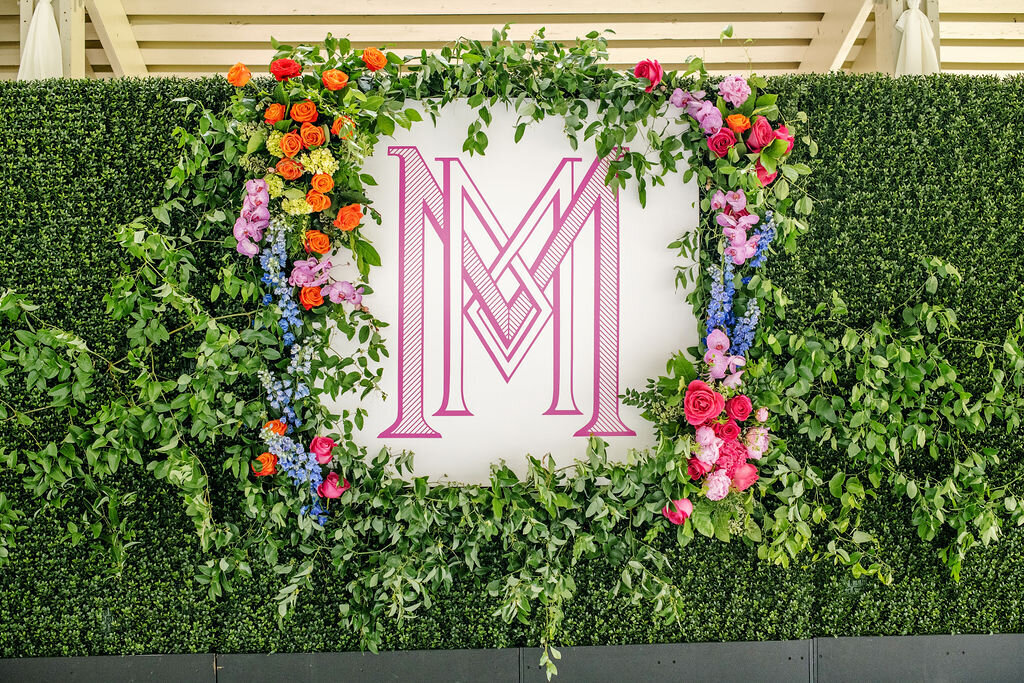 Custom monogram wall display with greenery and bright florals