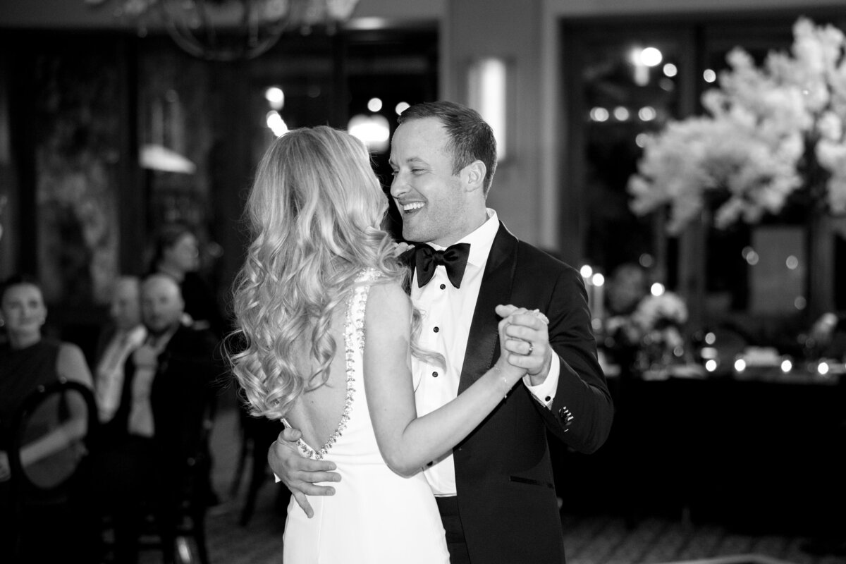 Bride and groom smiling while dancing at wedding reception