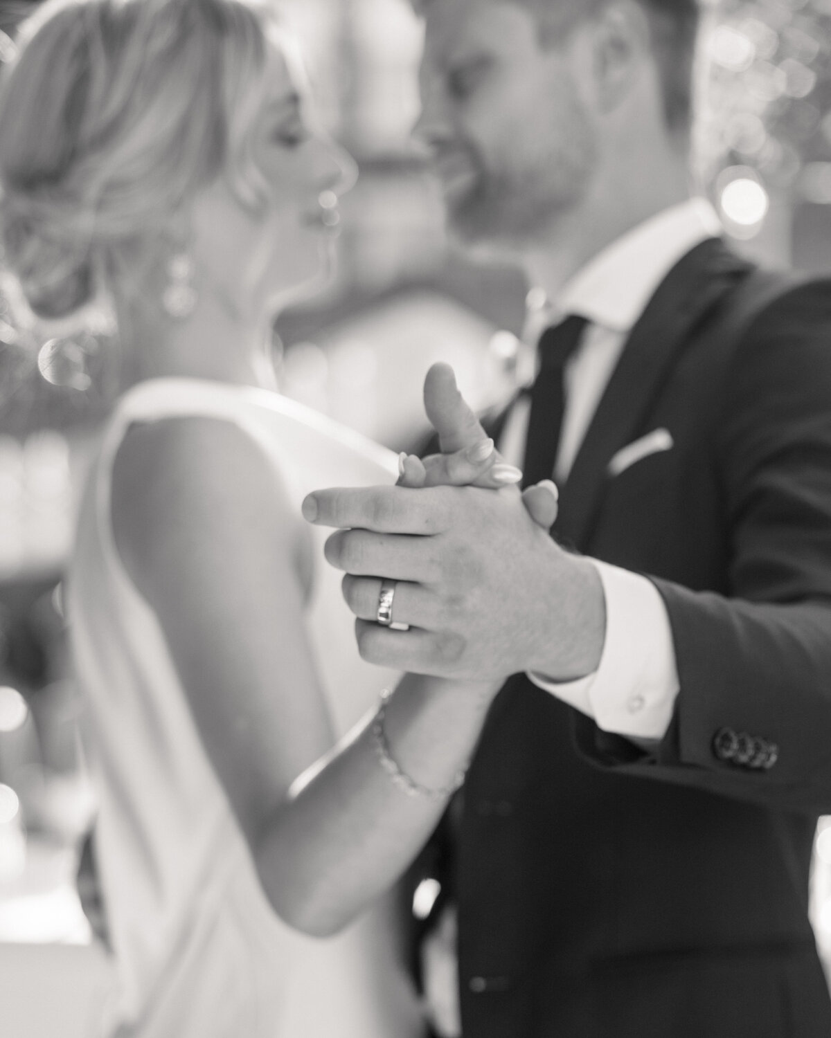 Black and white close-up of bride's and groom's holing hands in Dayton, Ohio, by Philadelphia wedding photographer.