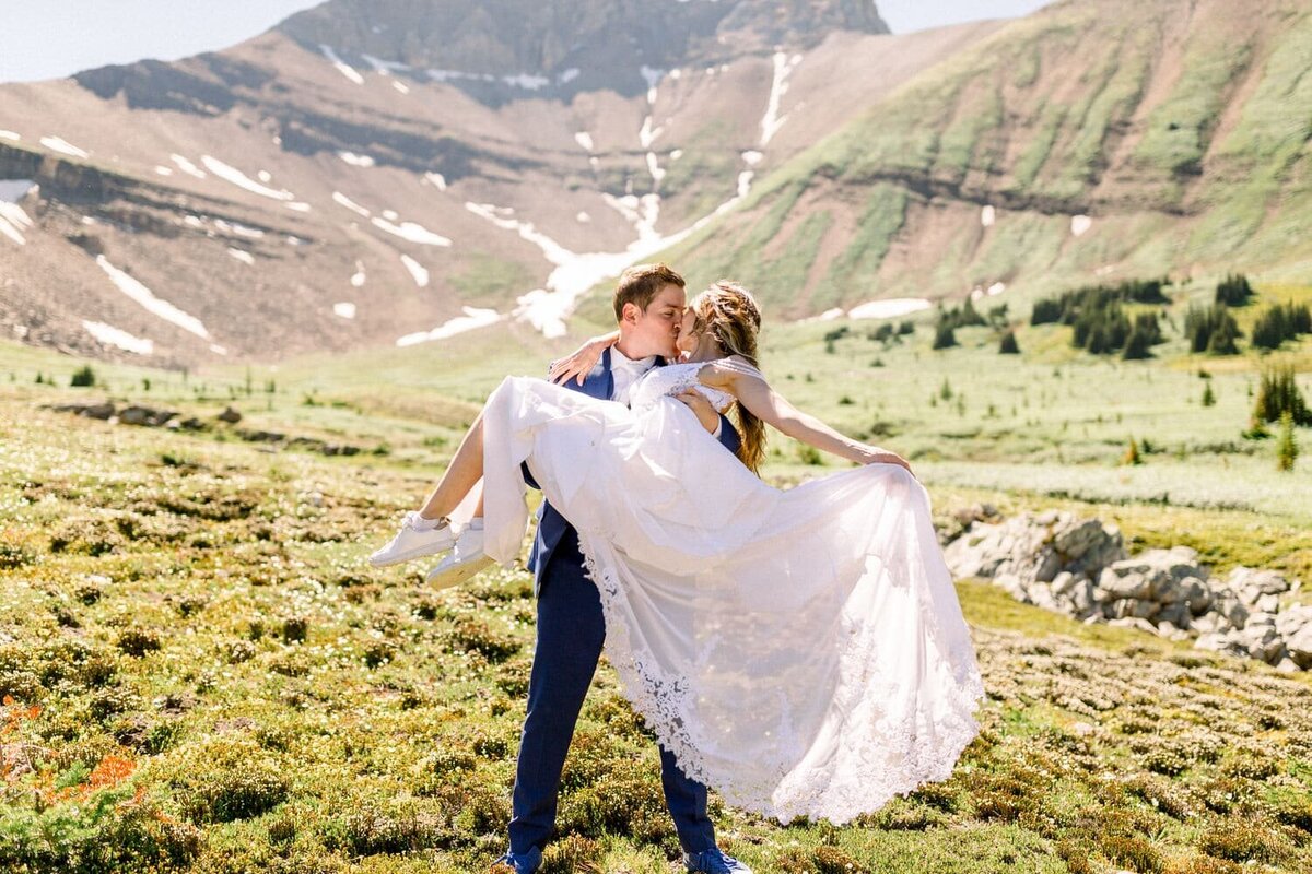Groom-picking-up-Bride-during-their-helicopter-mountain-wedding