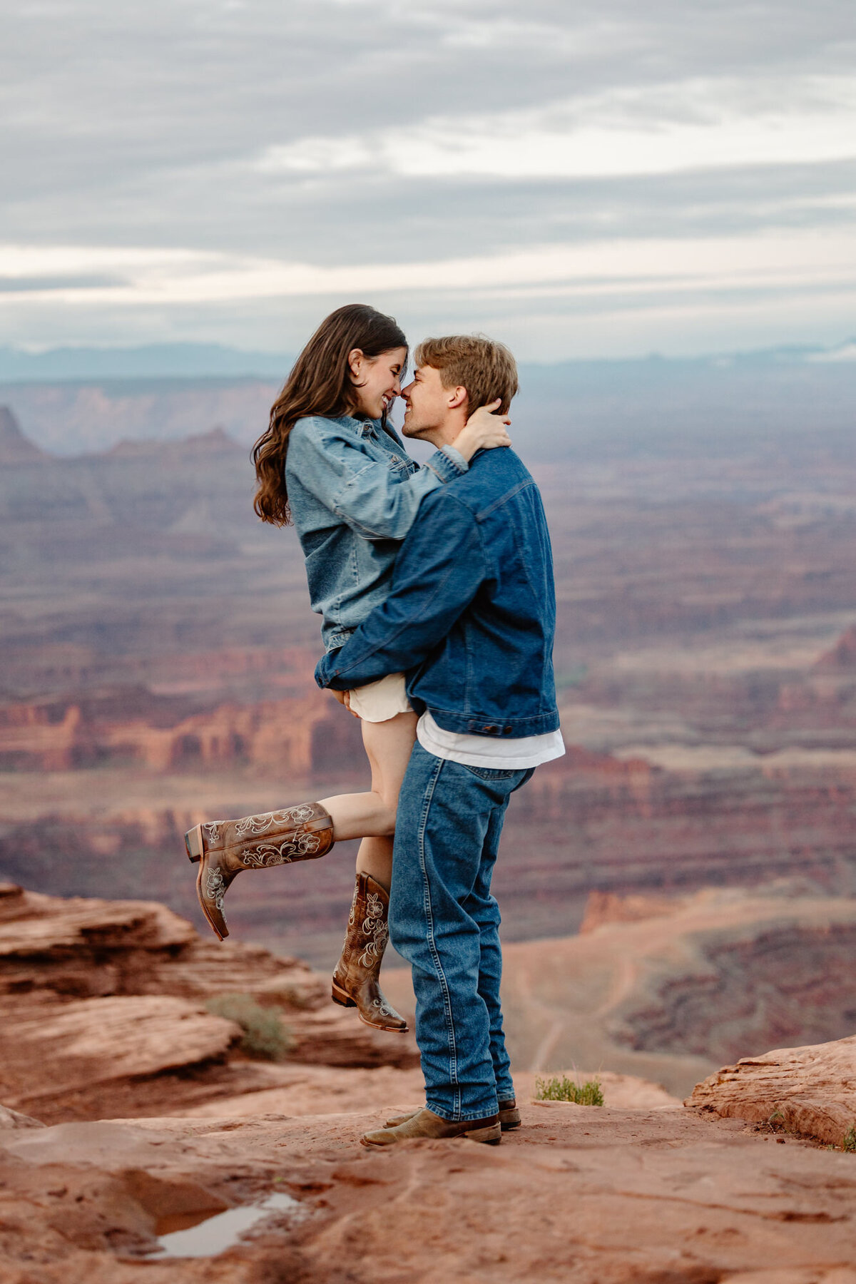 A groom picks up his bride during a sunrise adventure session on their elopement day. 