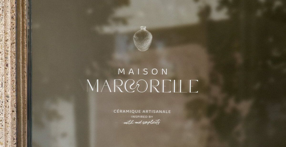 Vitrine Maison Marcorelle avec logo blanc en vitrophanie.