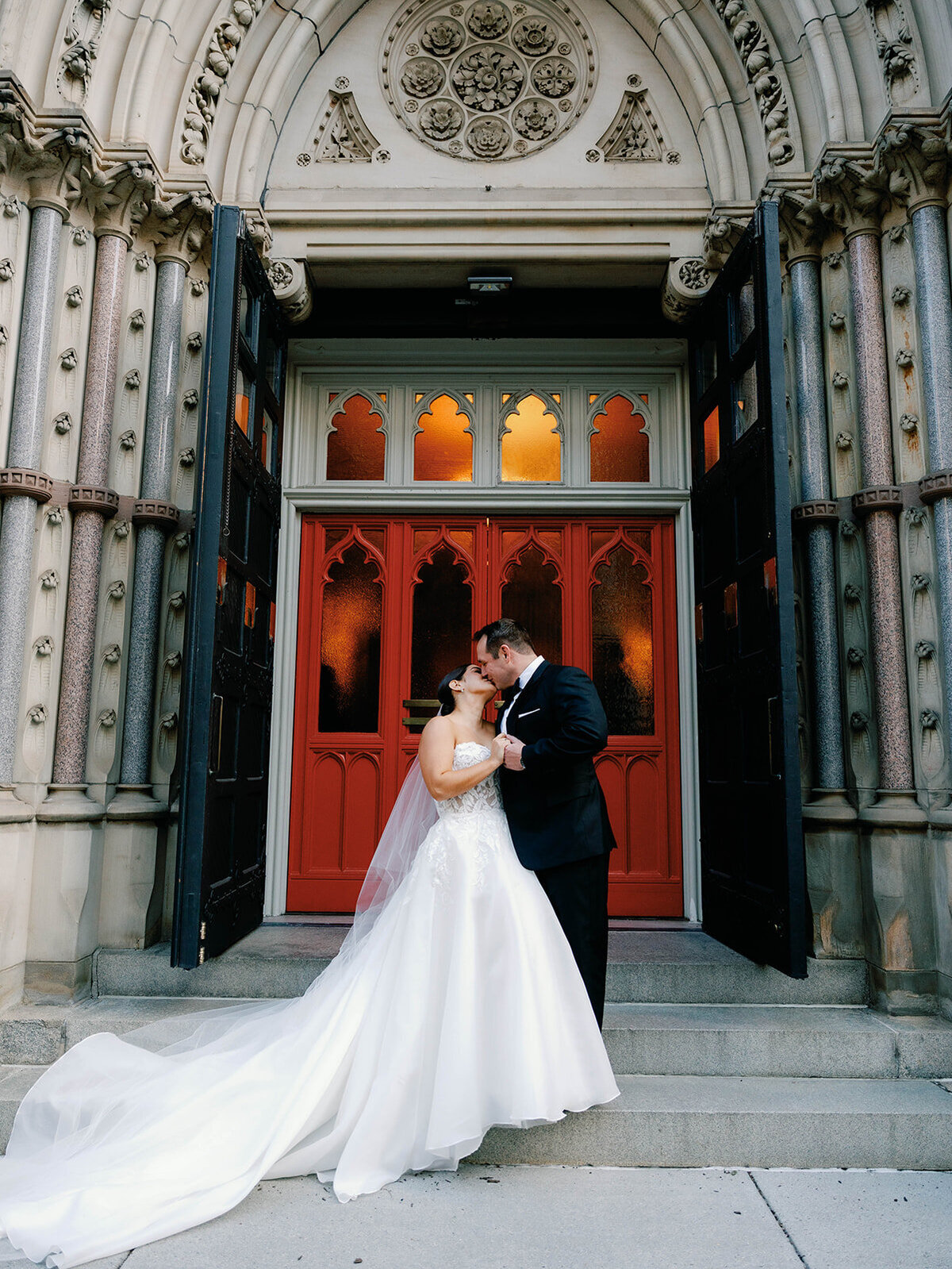 Bride and groom enjoy a kiss on the steps of the church