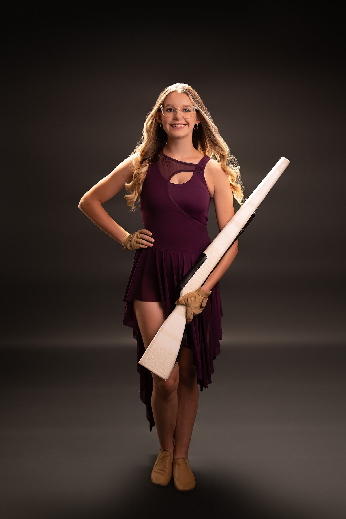 A member of the Arrowhead drill team poses for her senior portraits in our Waukesha studio wearing her uniform.