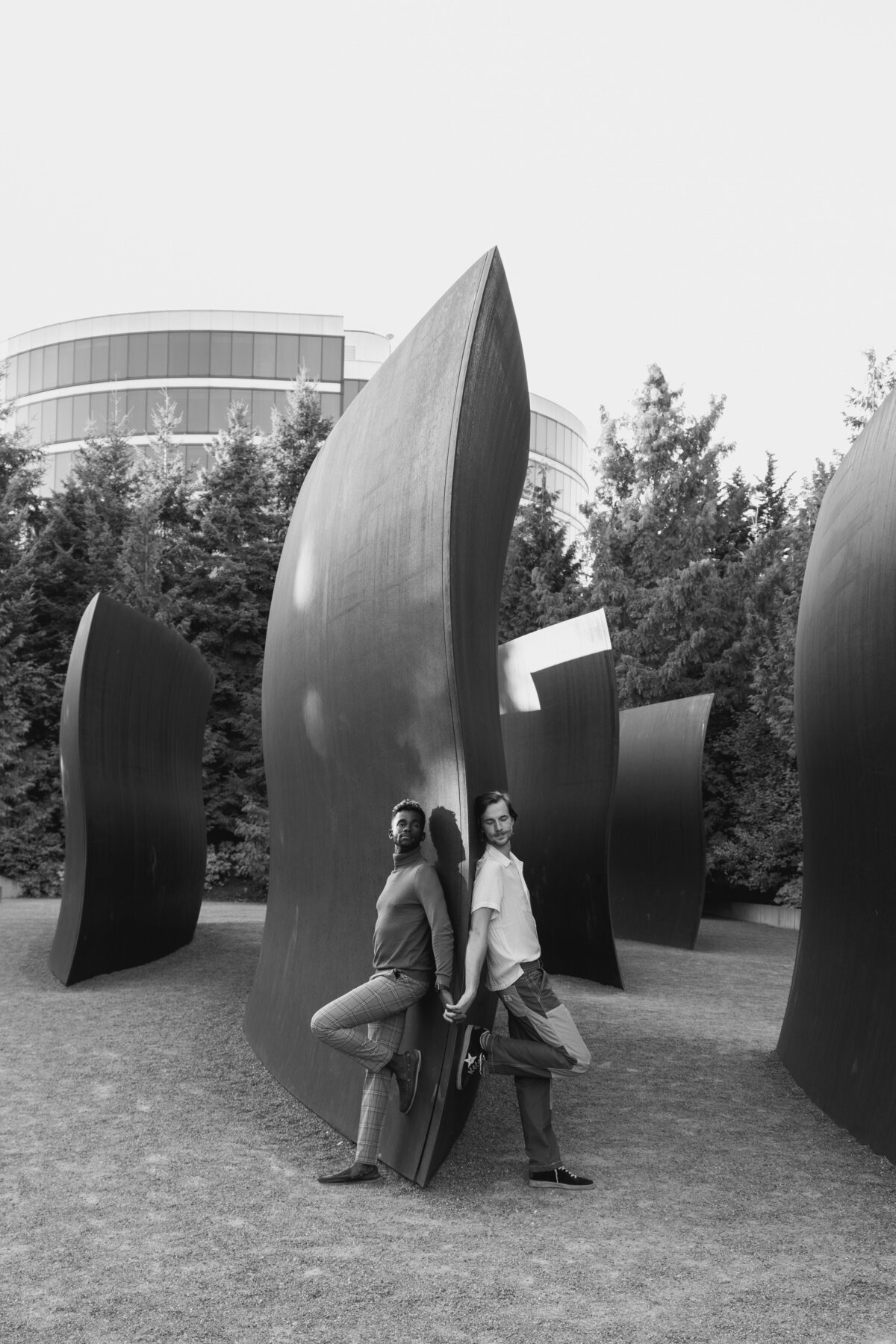 Black and white editorial of a queer engaged couple at the Olympic Sculpture Park in Seattle during golden hours 