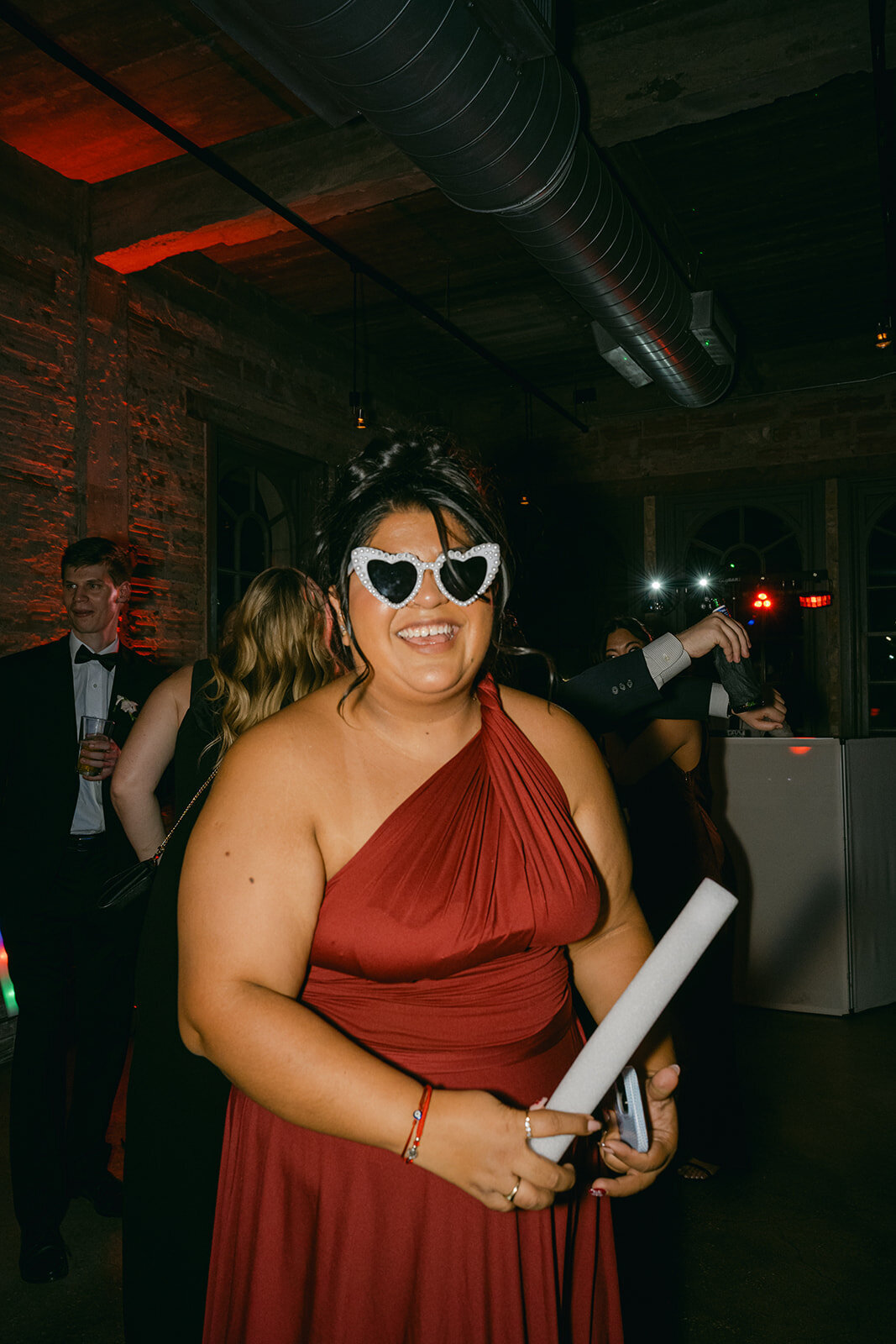 Stylish bridesmaid in red dress and retro sunglasses celebrating at luxury San Antonio reception