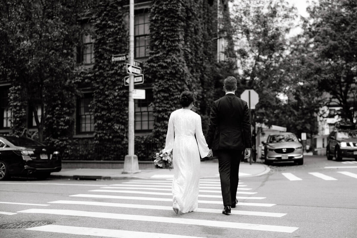 Back view of the bride and the groom crossing the street at West Village, NYC. Image by Jenny Fu Studio