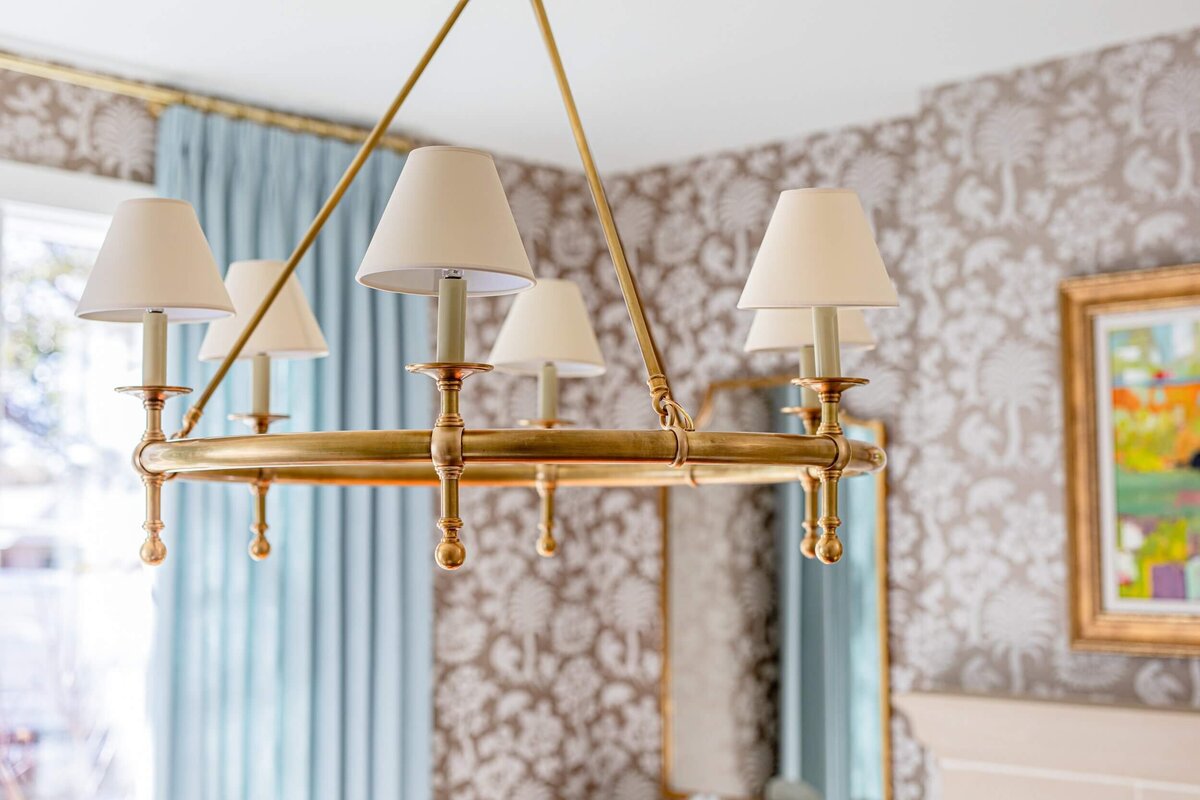 oyster creek studios highland park home  gold circular light fixture in room with taupe pattern wallpaper and blue curtains