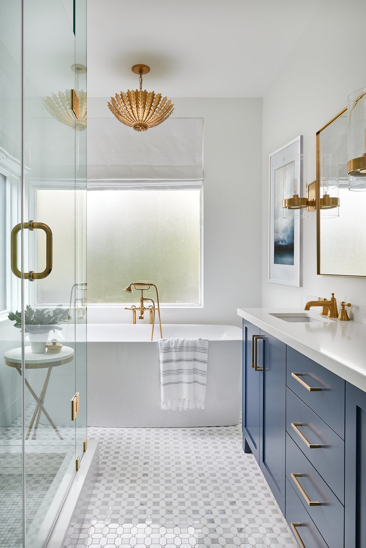 Toronto bathroom designed with marble floor, custom navy vanity, and gold interior fixtures