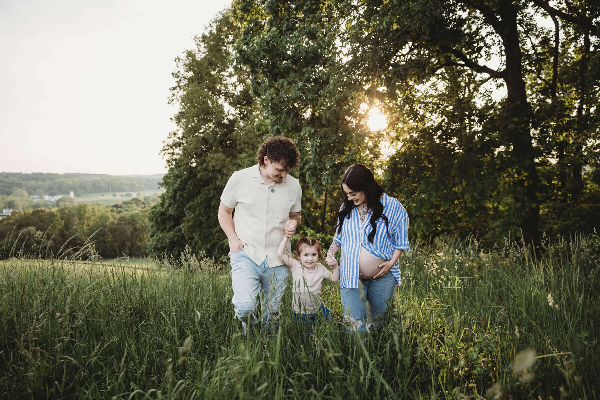 family walking in tall grass in portrait session with reva davis photography