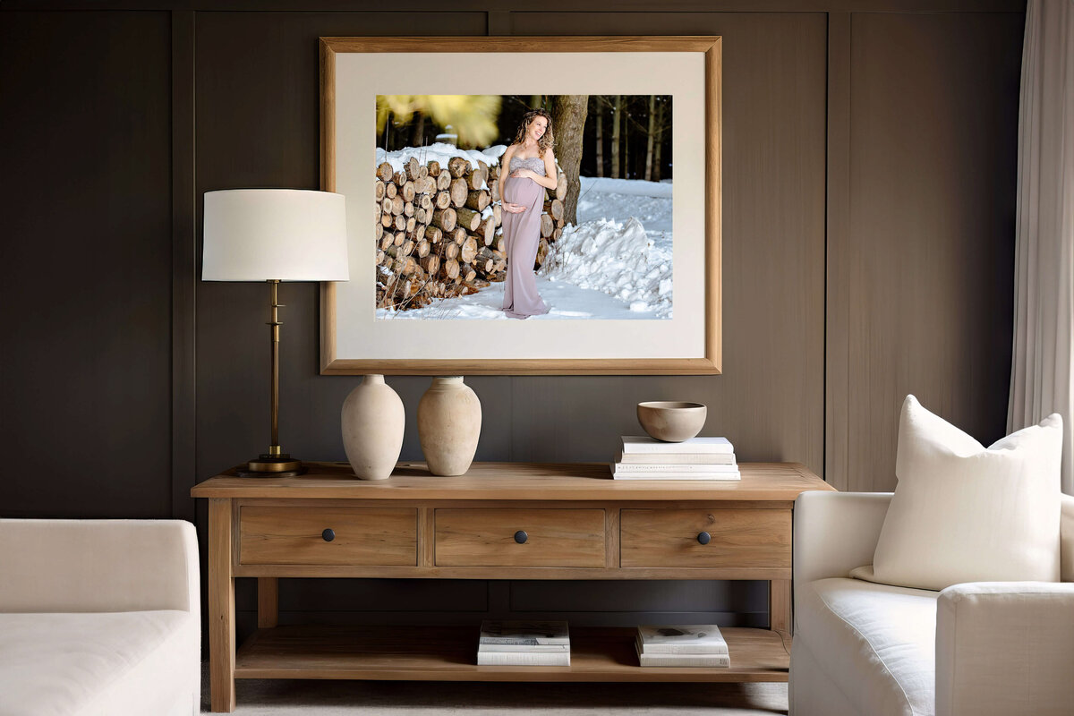 living room with a framed photo of a pregnant woman in the snow for her outdoor winter maternity photos in Burlington