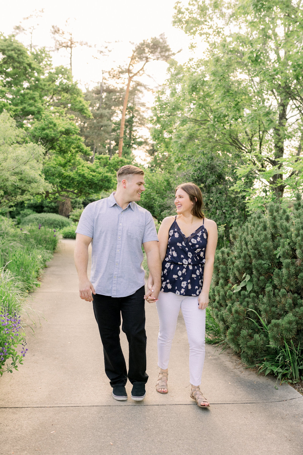 A couple walks and laughs towards each other during their engagement session