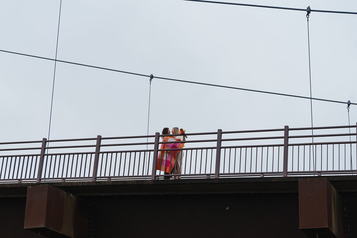 Women stand on a Tennessee bridge draped in a Lesbian Flag blanket 