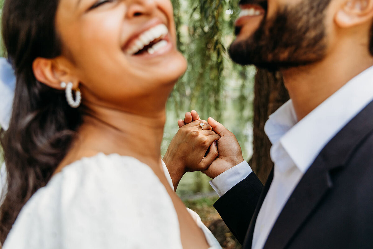 Engaged couple laugh during engagement portrait session