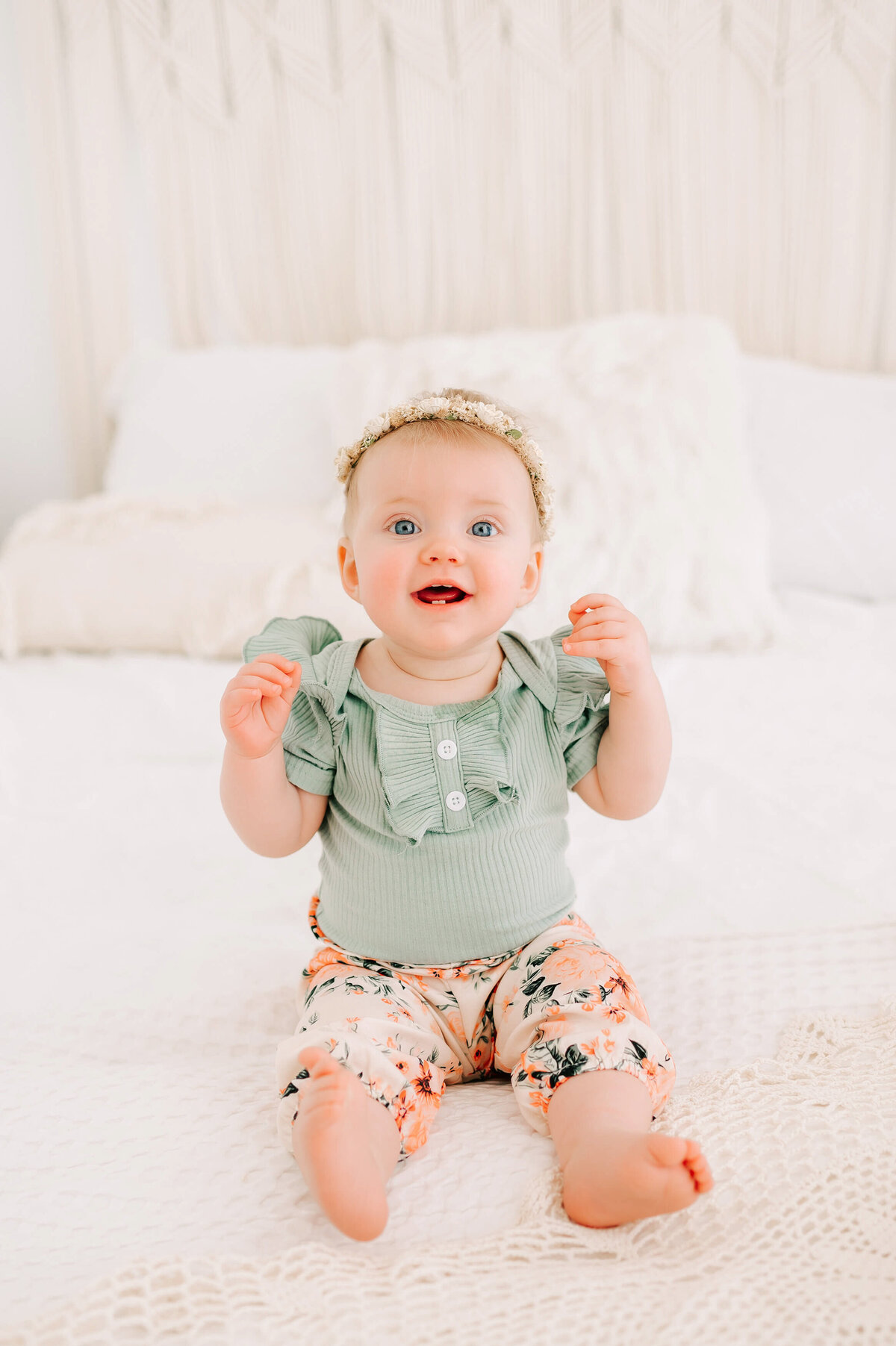 baby girl smiling on bed during Branson MO baby milestone session