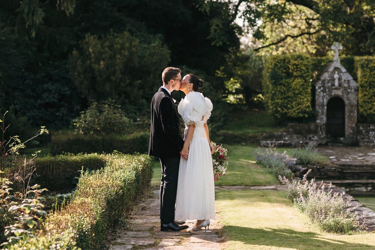 Wedding couple kiss in gardens on Dartmoor Devon