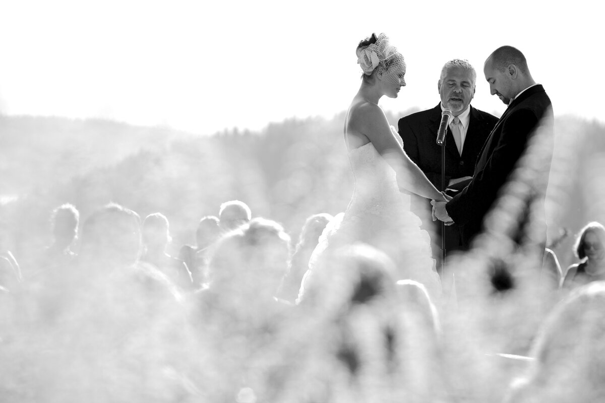 A bride and groom hold hands during the prayer at their Elk Point ceremony in Coeur d'Alene, Idaho.