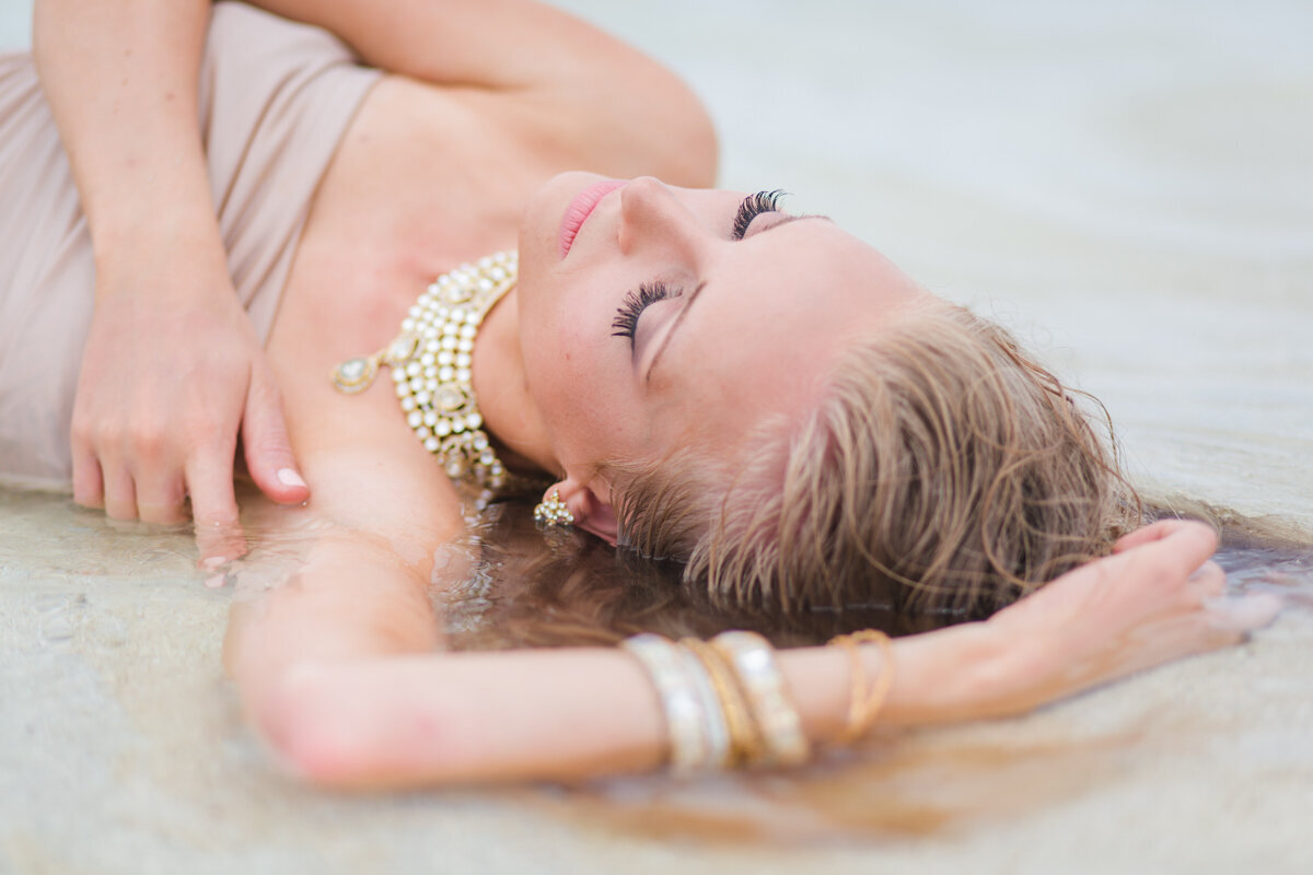 beautiful woman lying in the water in formal dress